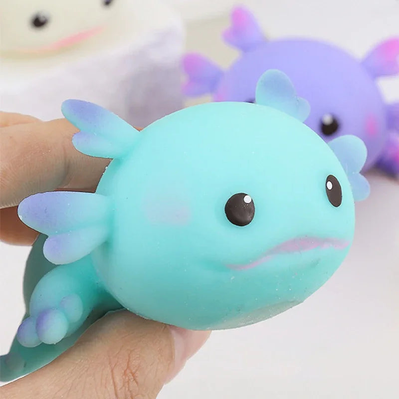 A hand squeezing a blue axolotl squishy, showing how soft it is.