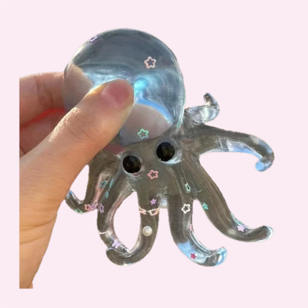 Blue glitter octopus squishy filled with liquid and floating glitter, held in a hand, on a pink background - Trendy Toyz AU