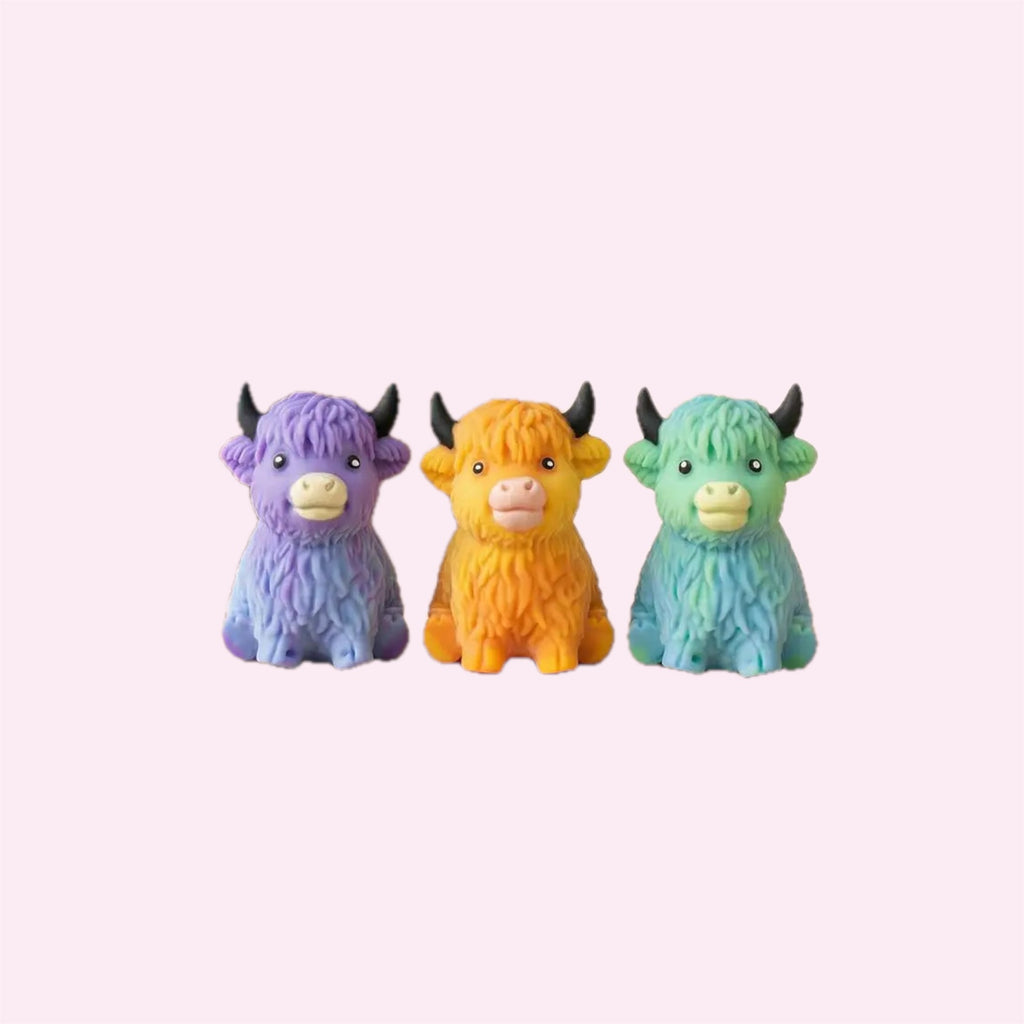 Three Highland Cow Squishies in purple, orange and green on a pink background - Trendy Toyz AU
