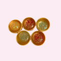 Mini mystery dumpling squishies opened to show glittery jelly buns inside golden steamer cases on a pink background - Trendy Toyz AU