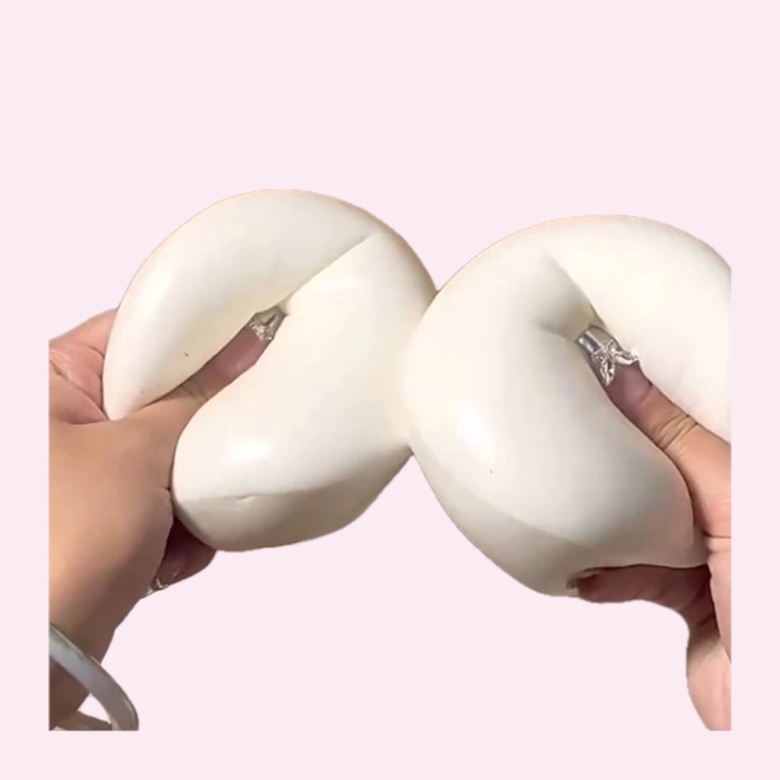 Giant yoghurt bun squishy being squashed with two hands on a pink background - Trendy Toyz AU