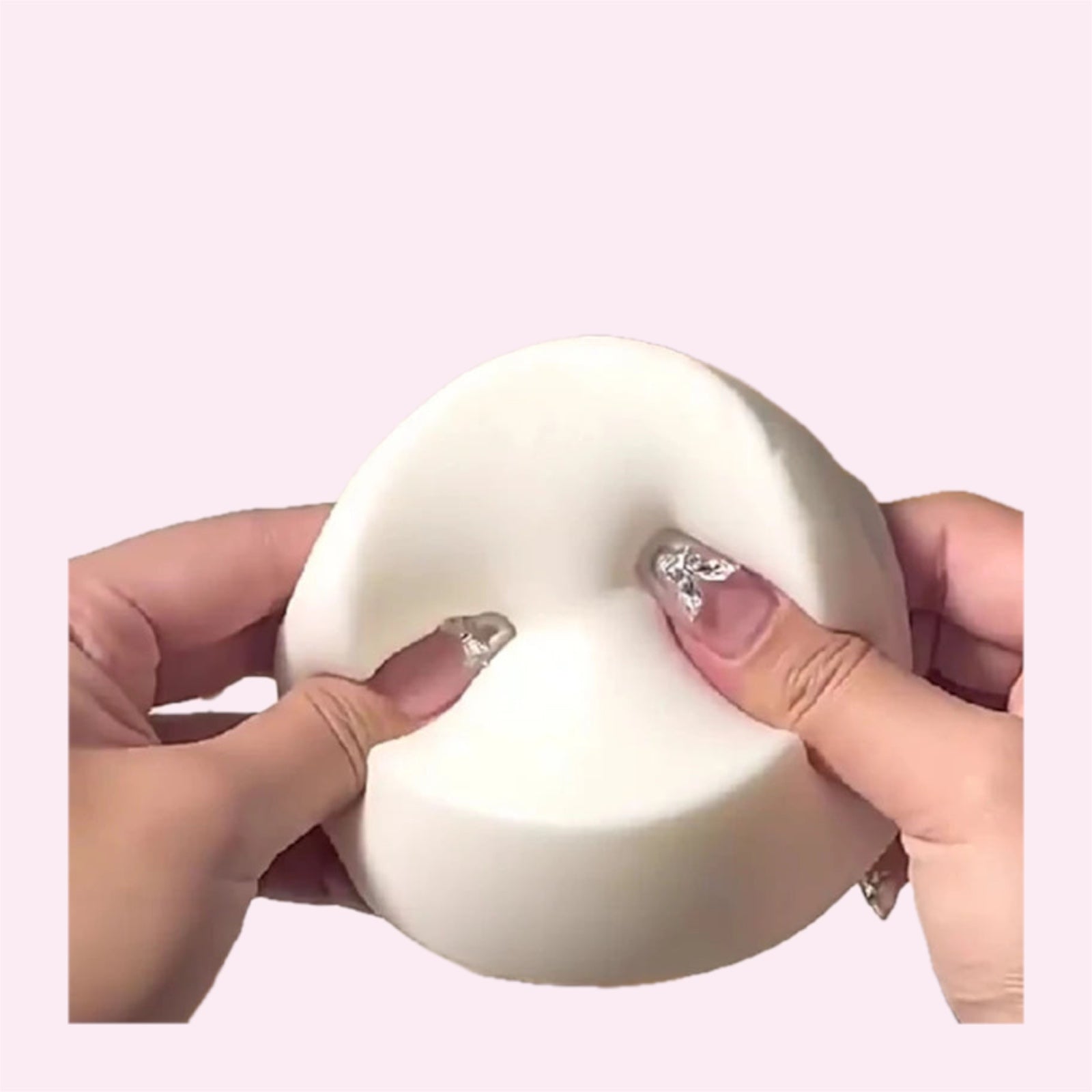 Giant yoghurt bun squishy being pressed with both thumbs on a pink background - Trendy Toyz AU